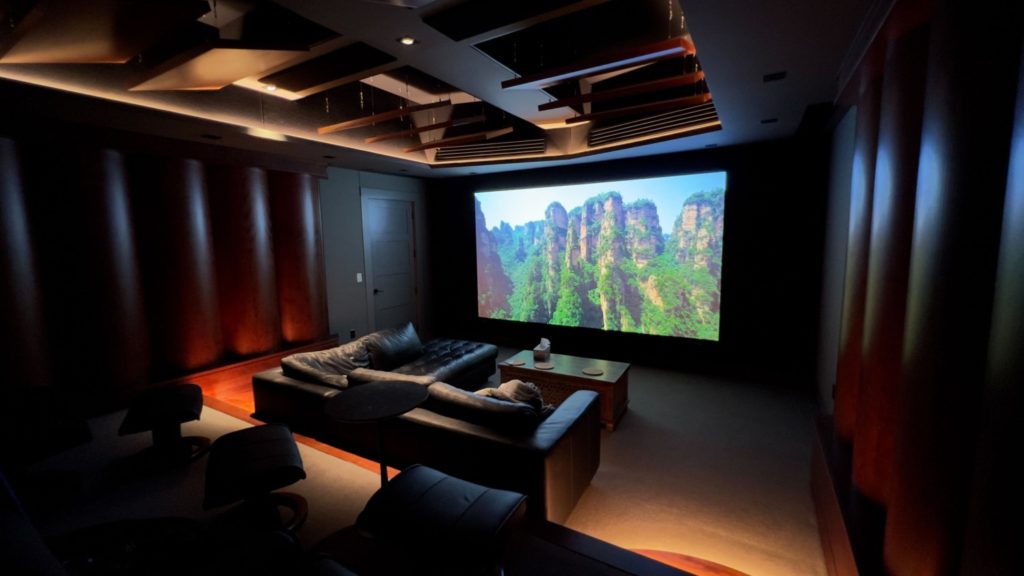 Beautiful home theatre system installed in Whistler, featuring staged seating, James speakers, a JVC projector, and Trinnov amplification for an immersive viewing and audio experience