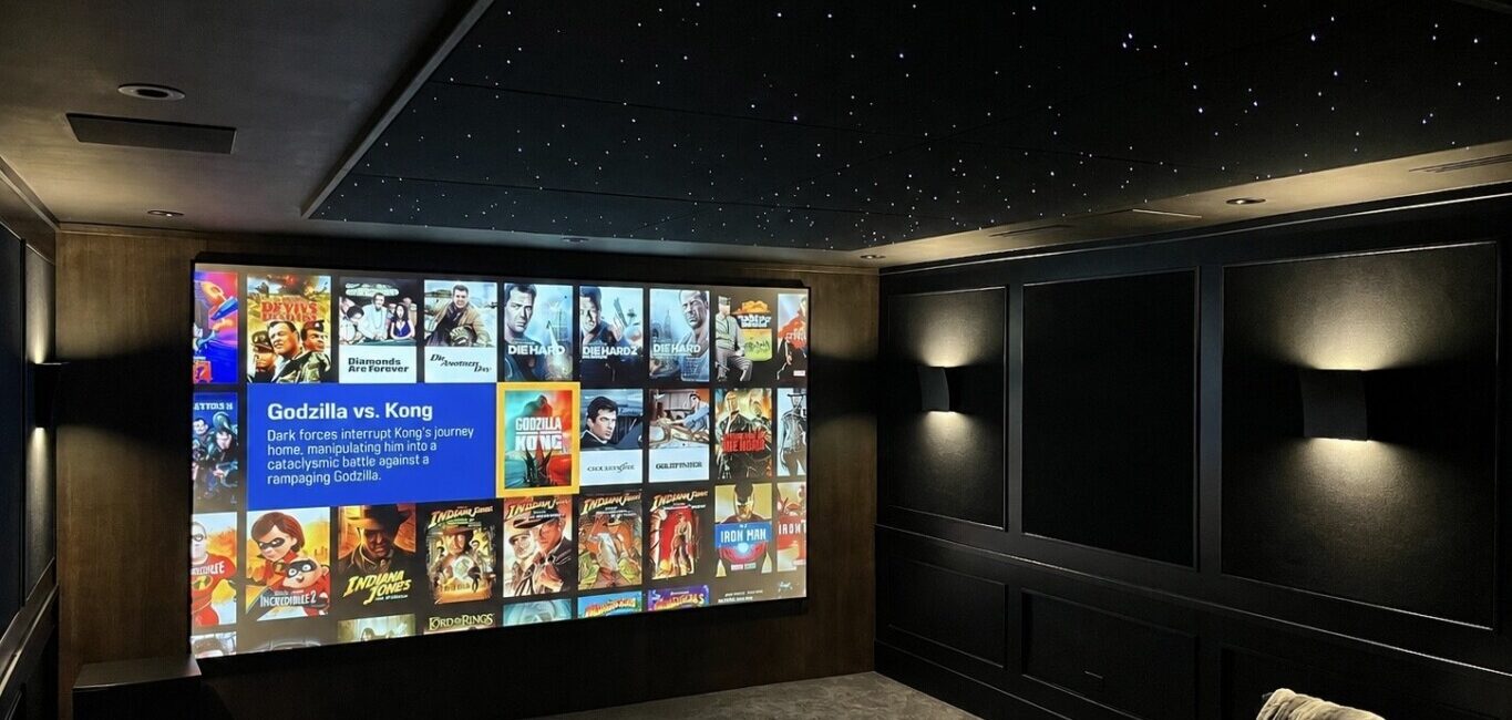Luxury home theatre in Whistler with tiered seating, projector and surround sound by Pure Image