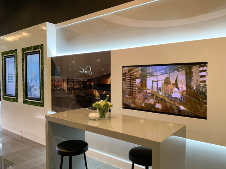 Presentation centre with wall-mounted displays above a stone counter