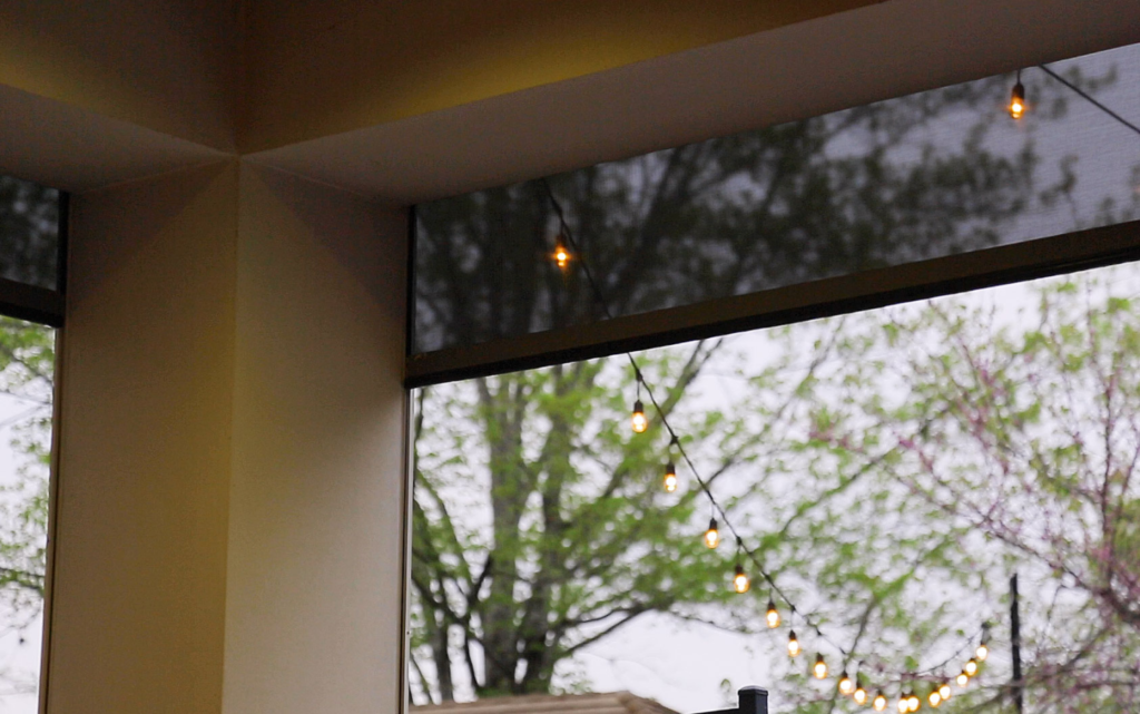 Lutron motorized roller shade in luxury Vancouver home with floor-to-ceiling windows — automated window coverings and smart shading control installed by Pure Image Vancouver BC