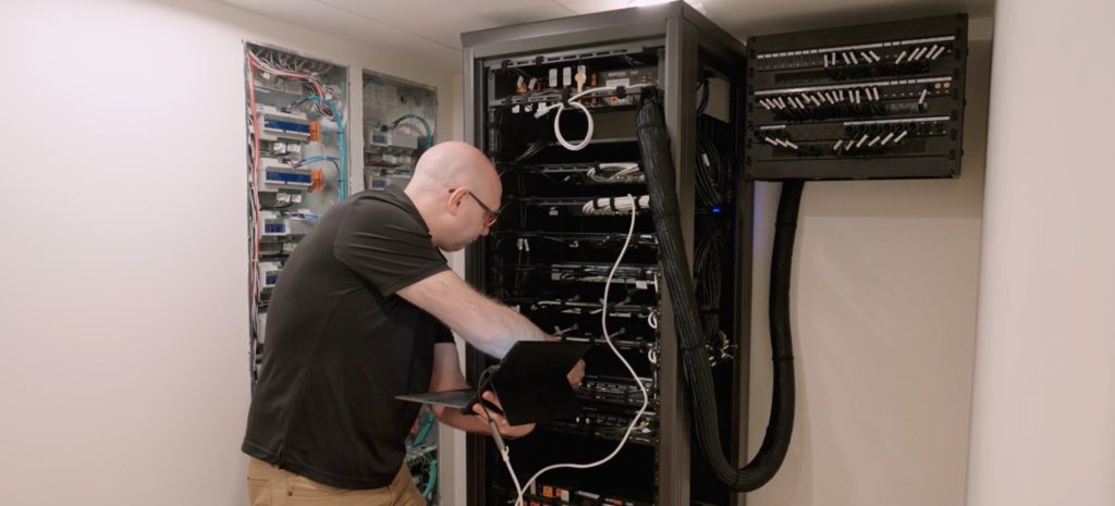 Pure Image technician working on a Crestron and Lutron automation system in a Whistler luxury home