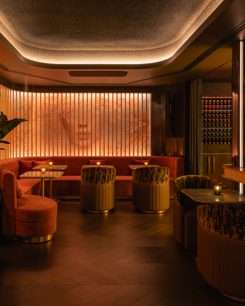 Prophecy Bar at Hotel Georgia, with fluted wall panelling, backlit artwork and a cascading crystal chandelier over velvet seating