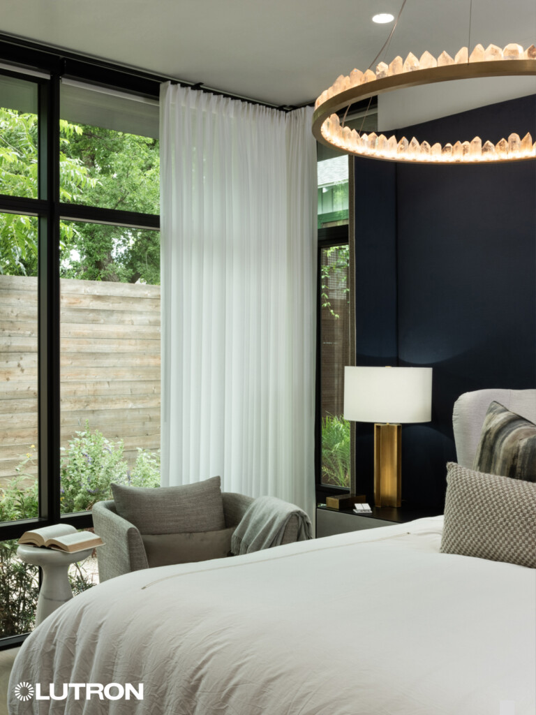 Stylish drapery paired with Lutron shades in the bedroom, offering a perfect balance of privacy, light control, and elegance. The combination of luxurious fabrics and advanced automation creates a serene, comfortable environment for rest and relaxation.