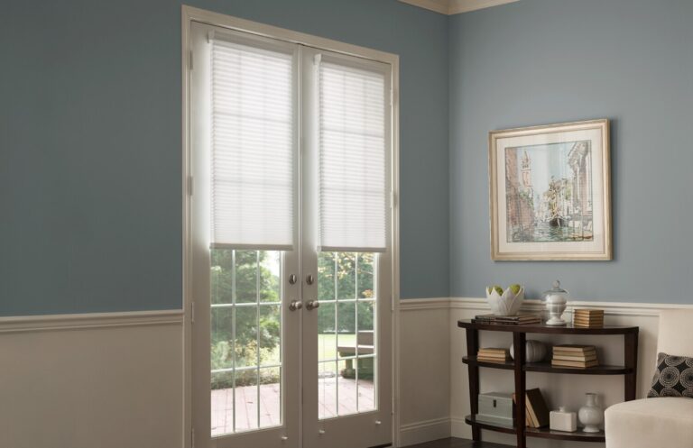 White honeycomb shades fitted to French doors in a blue-grey sitting room