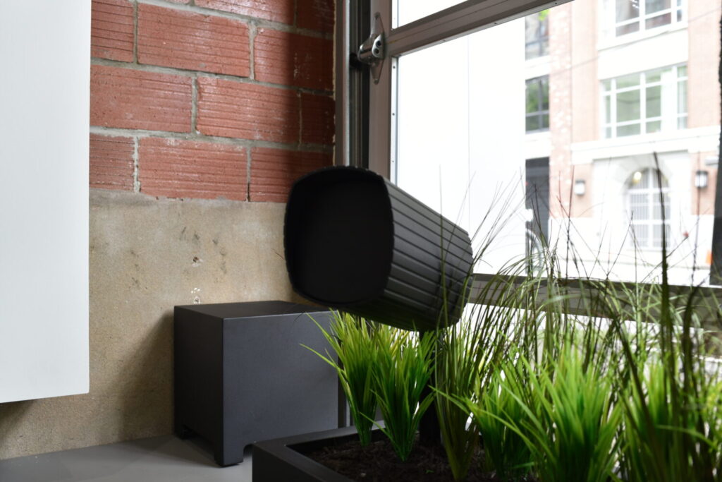 A James Loudspeaker Garden Series speaker on display in the Pure Image showroom—designed to deliver powerful, high-fidelity sound outdoors, this sleek, weather-resistant fixture blends into landscaping with a refined, architectural finish. Paired with buried subwoofers, it offers a discreet yet immersive outdoor audio experience.