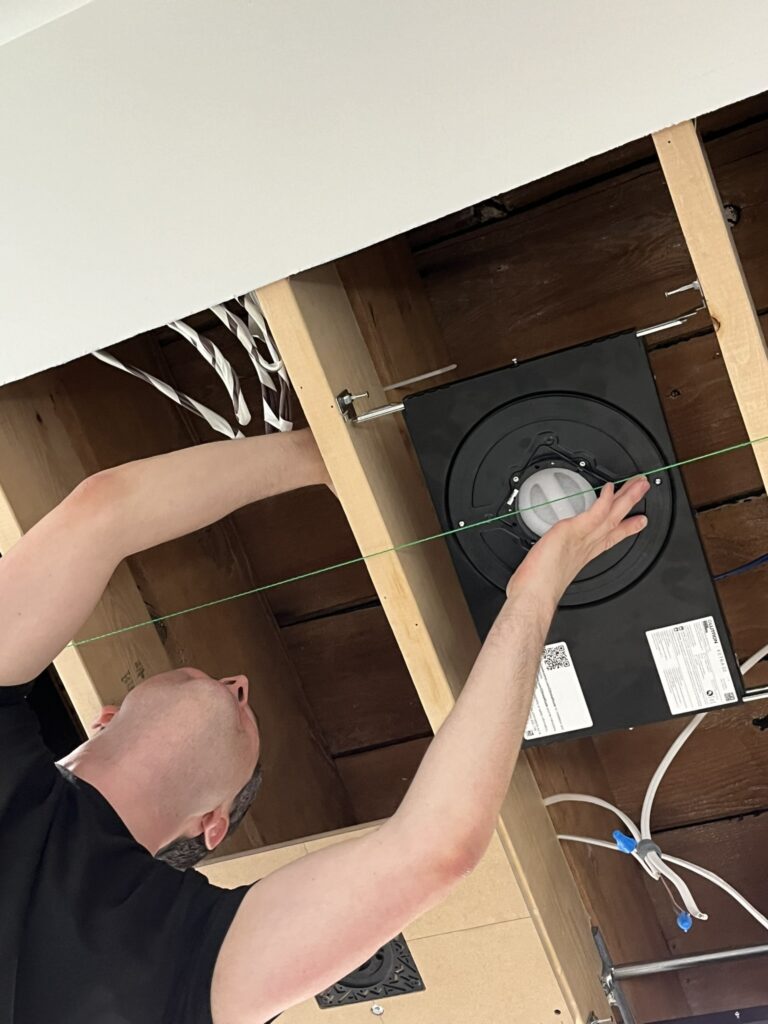 A Ketra D2 potlight partially installed—captured mid-process with wiring exposed and ceiling access open. This moment highlights the precision and care taken to bring Lutron’s most advanced, natural light technology into the space, delivering unmatched quality and seamless architectural integration.