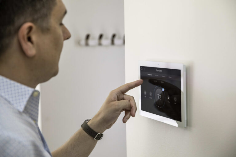 Crestron Home touchscreen controlling lighting and audio in a modern living space