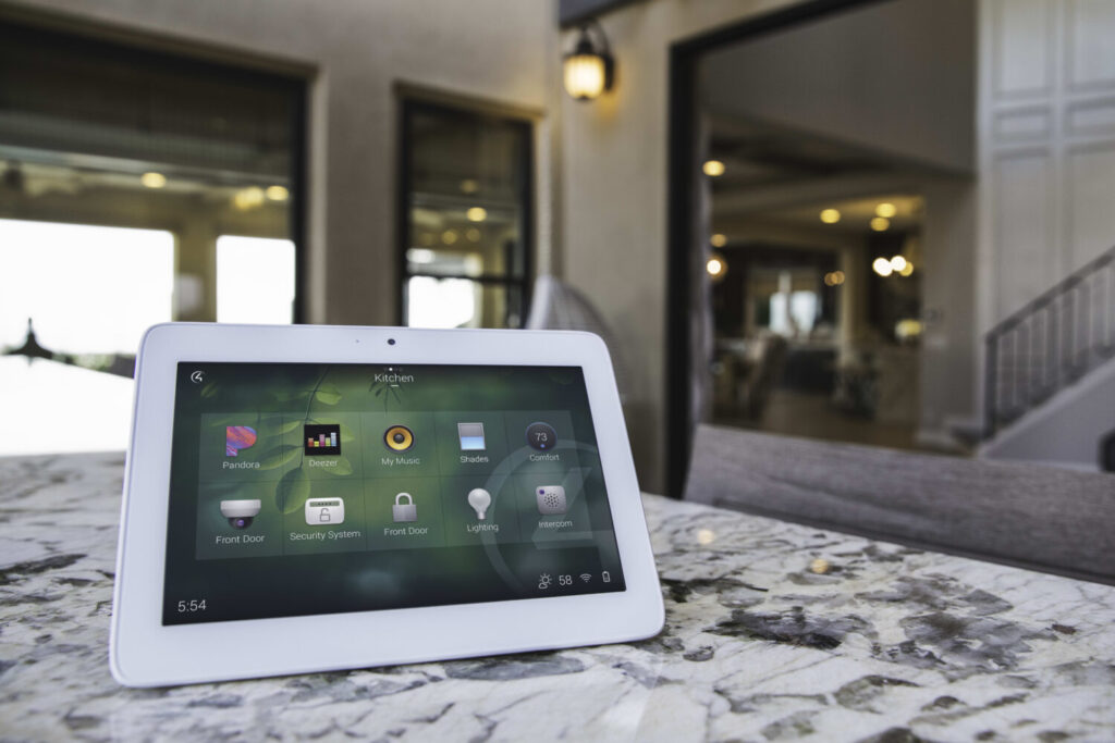 Control4 smart home touchscreen on a table in a modern Vancouver luxury home, showing intuitive automation controls for lighting, shades, audio, and climate by Pure Image.