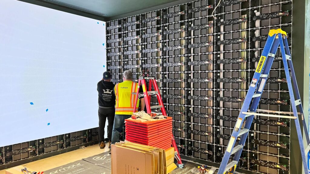 Pure Image technicians installing a massive full room LED video wall in Vancouver, showcasing advanced commercial AV integration and precision engineering.