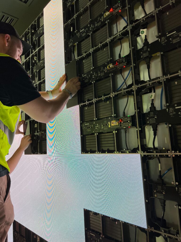Close-up view of Pure Image specialist calibrating an LED video wall during installation, ensuring perfect alignment and seamless digital performance.