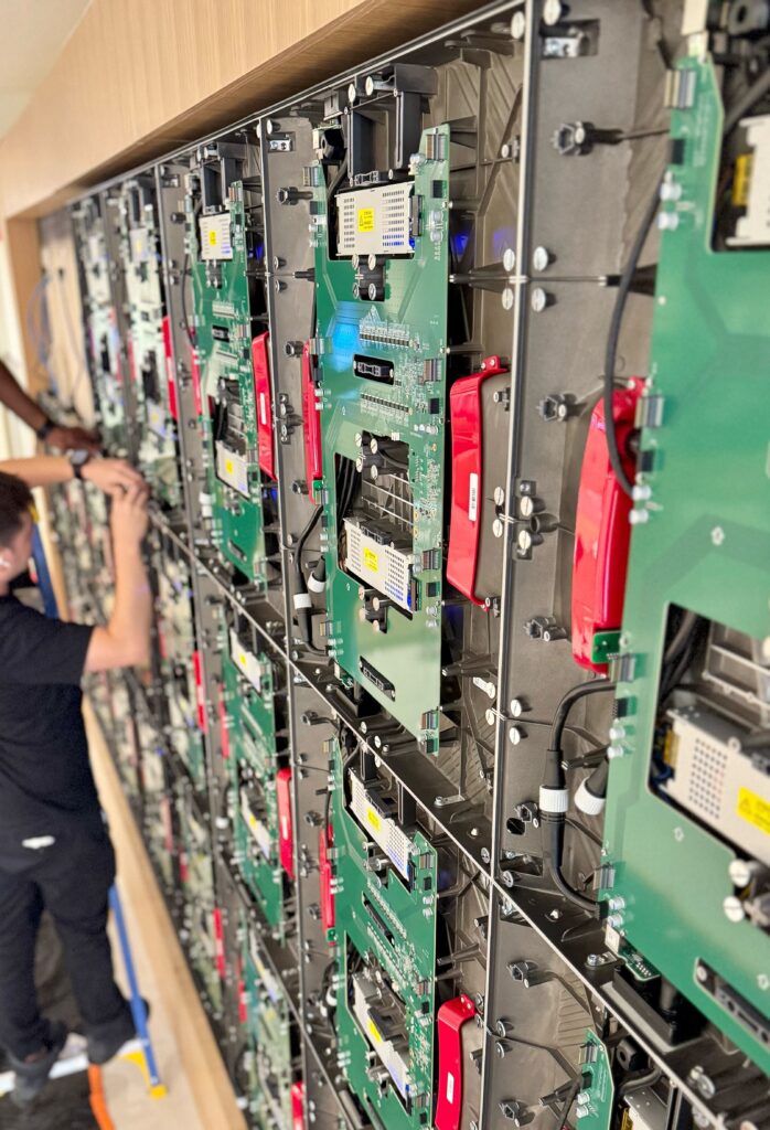 Pure Image installing individual MicroLED video wall tiles, capturing the technical setup and alignment before completing the full 220-inch display