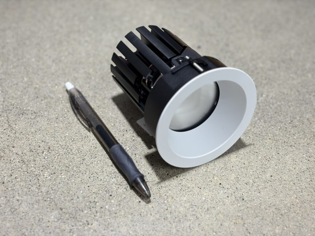 Ketra D2R small aperture remodeler downlight shown next to a pen for scale — compact Ketra retrofit lighting available at Pure Image Vancouver showroom
