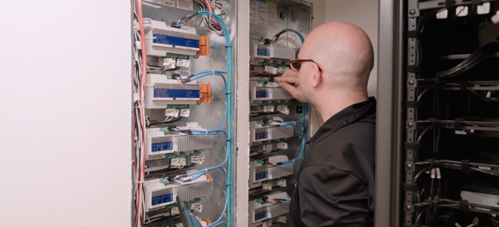 Pure Image technician servicing Crestron and Lutron smart home equipment rack — dedicated home theatre service and maintenance by Pure Image Technology Vancouver BC