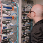 Pure Image technician servicing Crestron and Lutron smart home equipment rack — dedicated home theatre service and maintenance by Pure Image Technology Vancouver BC
