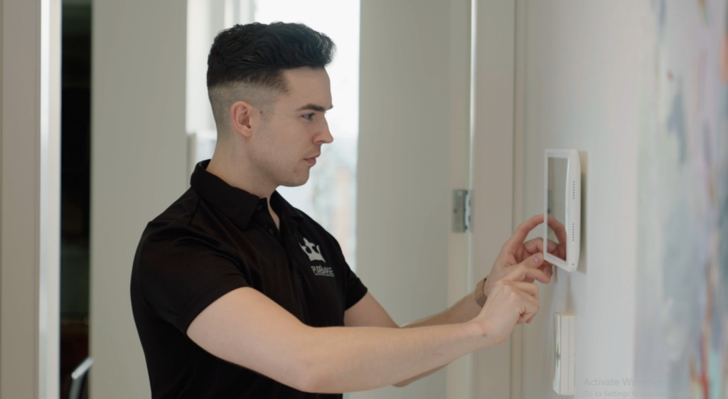 Pure Image technician installing smart home touchscreen in luxury Vancouver residence — professional smart home automation installation and commissioning by Pure Image Vancouver BC