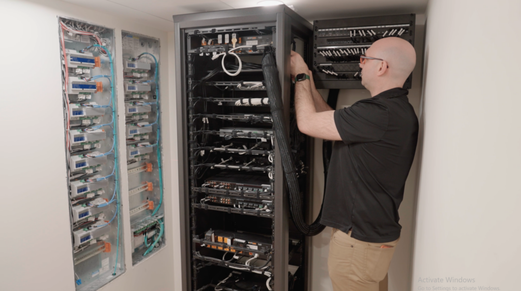 Pure Image technician servicing custom smart home equipment rack with Crestron and networking infrastructure — expert smart home installation and service by Pure Image Vancouver BC