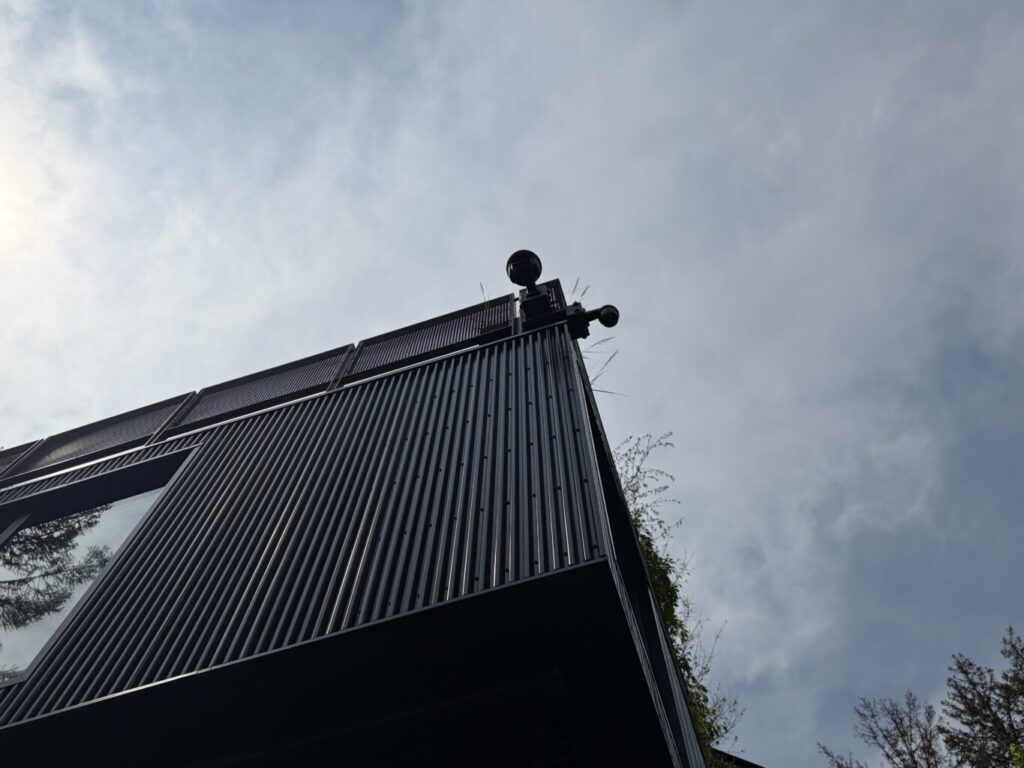 Exterior security cameras mounted on the corner of a modern home, providing wide surveillance coverage of the property, installed by Pure Image.