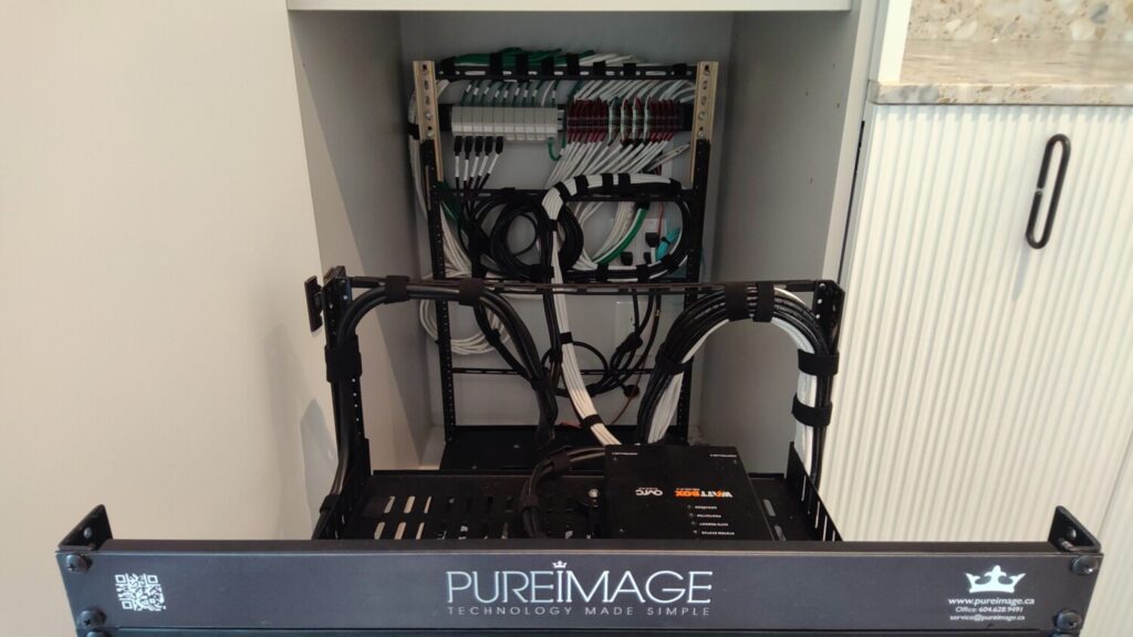 Custom Pure Image equipment rack with organized network and automation gear installed in a Vancouver home's mechanical room.