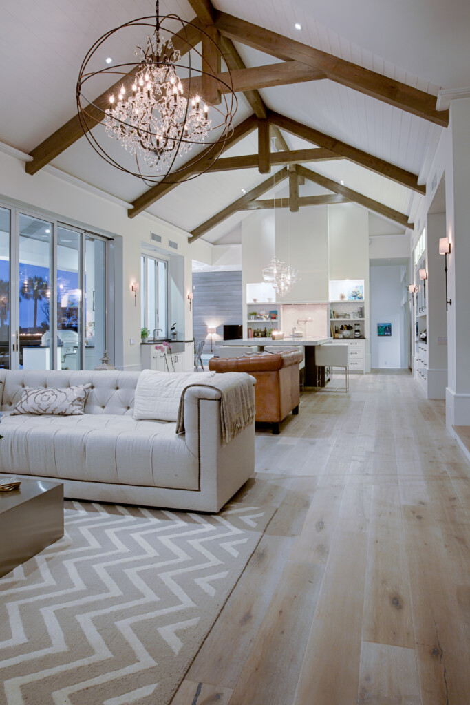 Lutron lighting control across an open-plan living room with a vaulted white ceiling and exposed wood beams